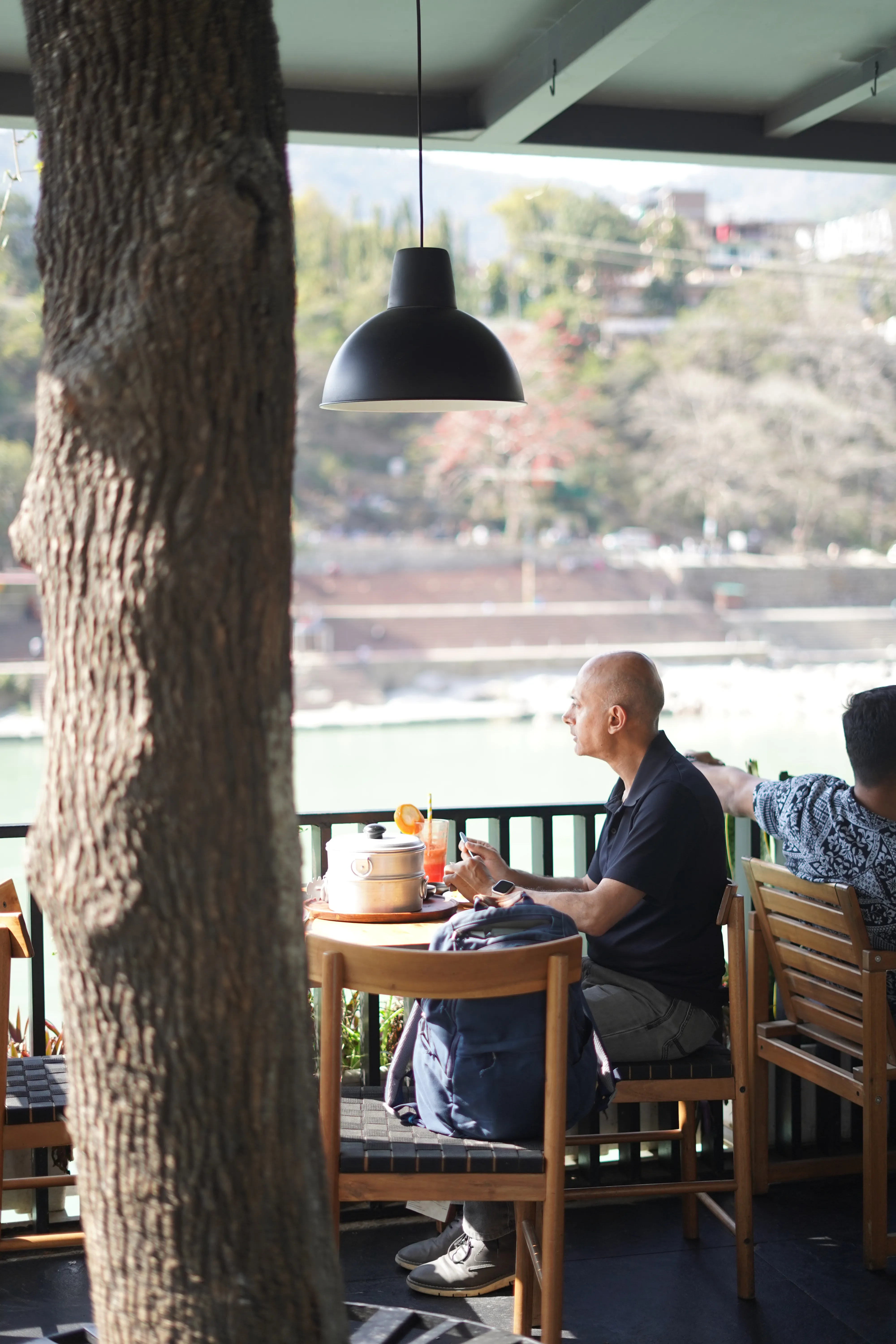>Person enjoying food with ganga view